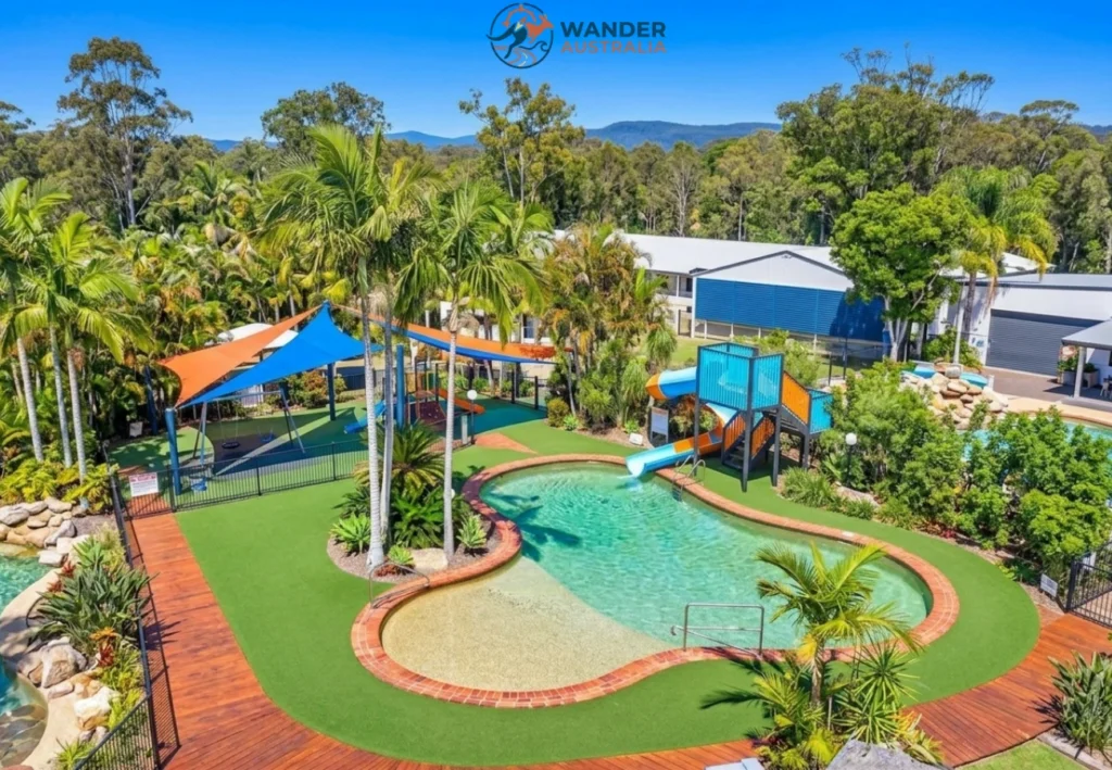Resort pool and water slide surrounded by tropical gardens image